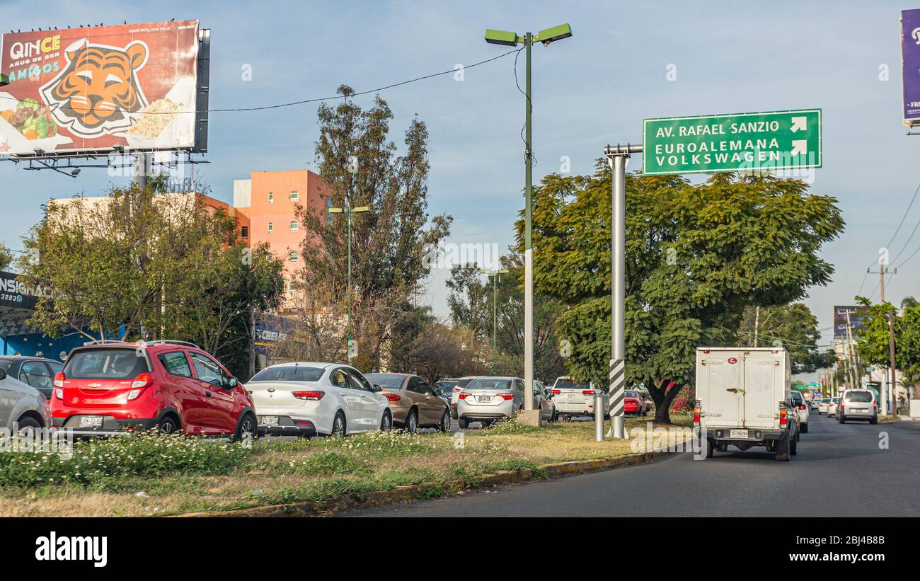 Guadalajara, Jalisco / Mexique. 14 janvier. 2020. Journée encombrée avec beaucoup de trafic dans les rues de la ville parmi les arbres, les câbles et les grandes enseignes commerciales Banque D'Images