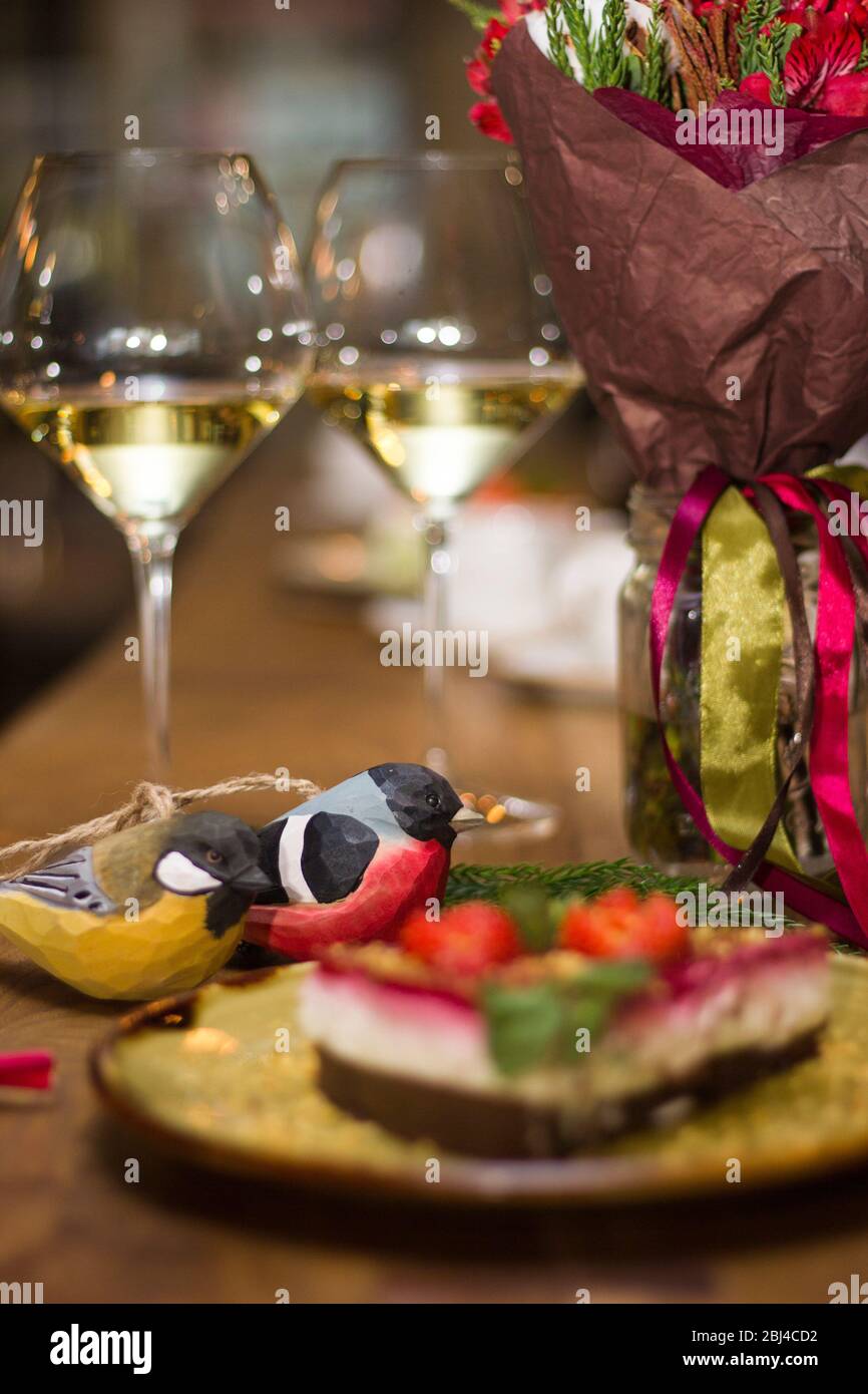 Verres de vin blanc et jouets de Noël sur la table de fête Banque D'Images