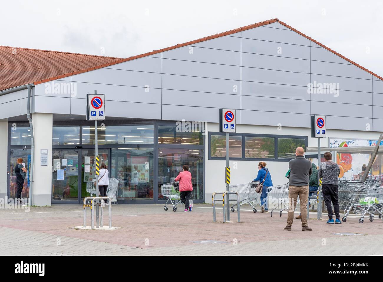 Les personnes avec masques de protection faisant la queue devant un supermarché en raison du coronavirus Covid-19 qui oblige les clients à faire des entrées sur quota Banque D'Images