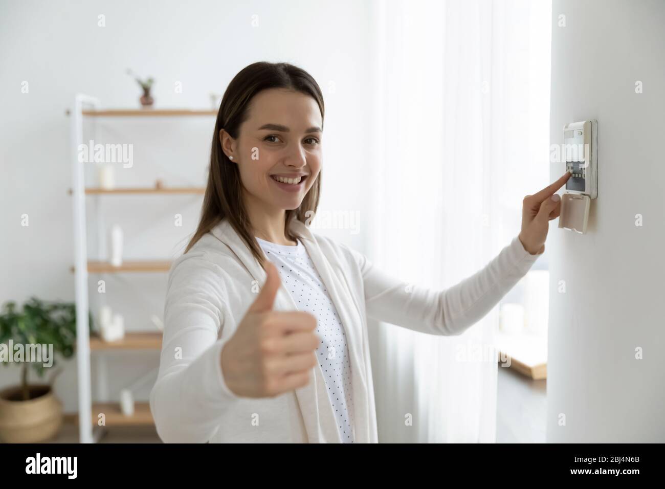 Une femme souriante utilise un système de panneau de commande intelligent Banque D'Images