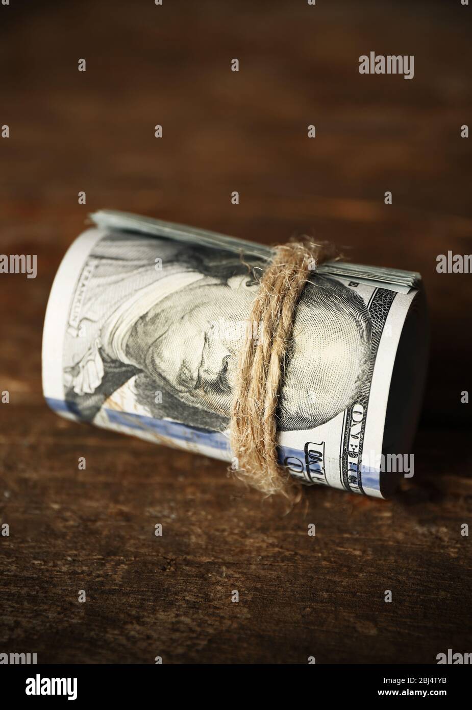 Les dollars roulent sur fond en bois Banque D'Images
