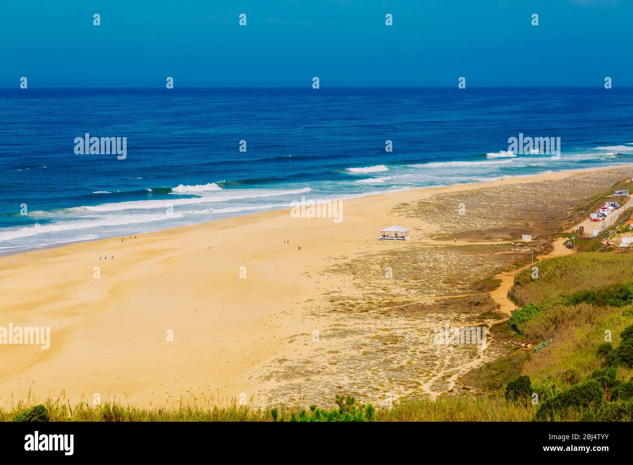 Vue sur la plage de sable du nord et l'océan Atlantique bleu à Nazaré, Portugal Banque D'Images