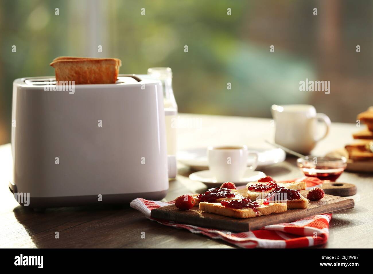 Table pour le petit-déjeuner avec toasts et café, sur fond flou Banque D'Images