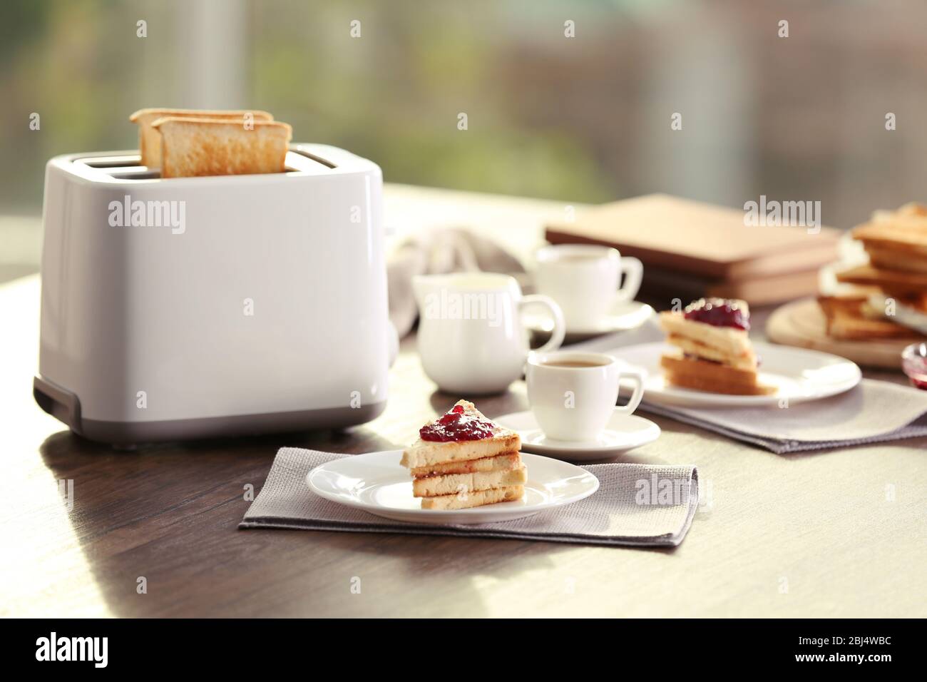 Table pour le petit-déjeuner avec toasts et café, sur fond flou Banque D'Images