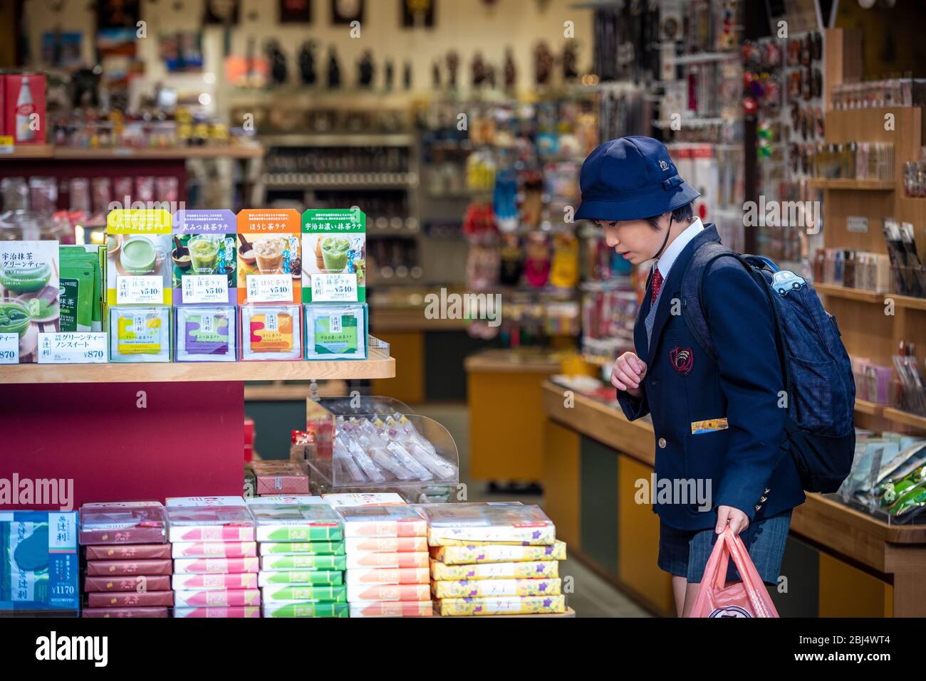 Un étudiant japonais portant un uniforme scolaire passant par une boutique de souvenirs dans la rue Matsubara Dori à kyoto, au Japon Banque D'Images