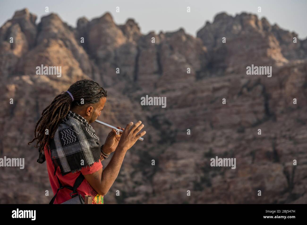 Le son d'une flûte fait écho dans les montagnes de Jordanie comme un homme bédouin s'arrête de jouer. Banque D'Images