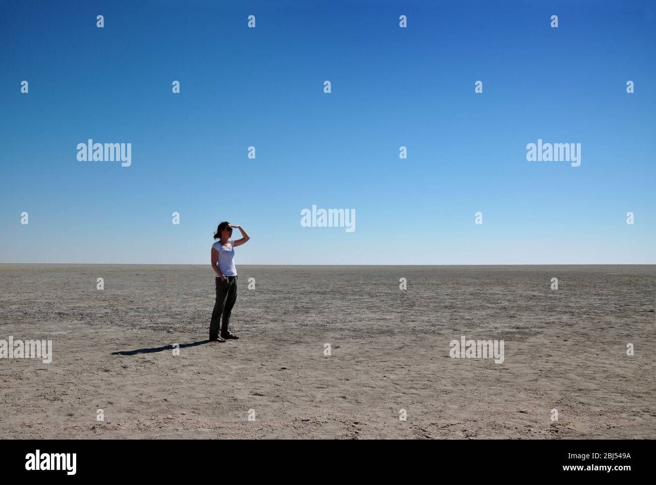 Femme regardant la distance à Etosha PAN, Namibie, Afrique. Banque D'Images