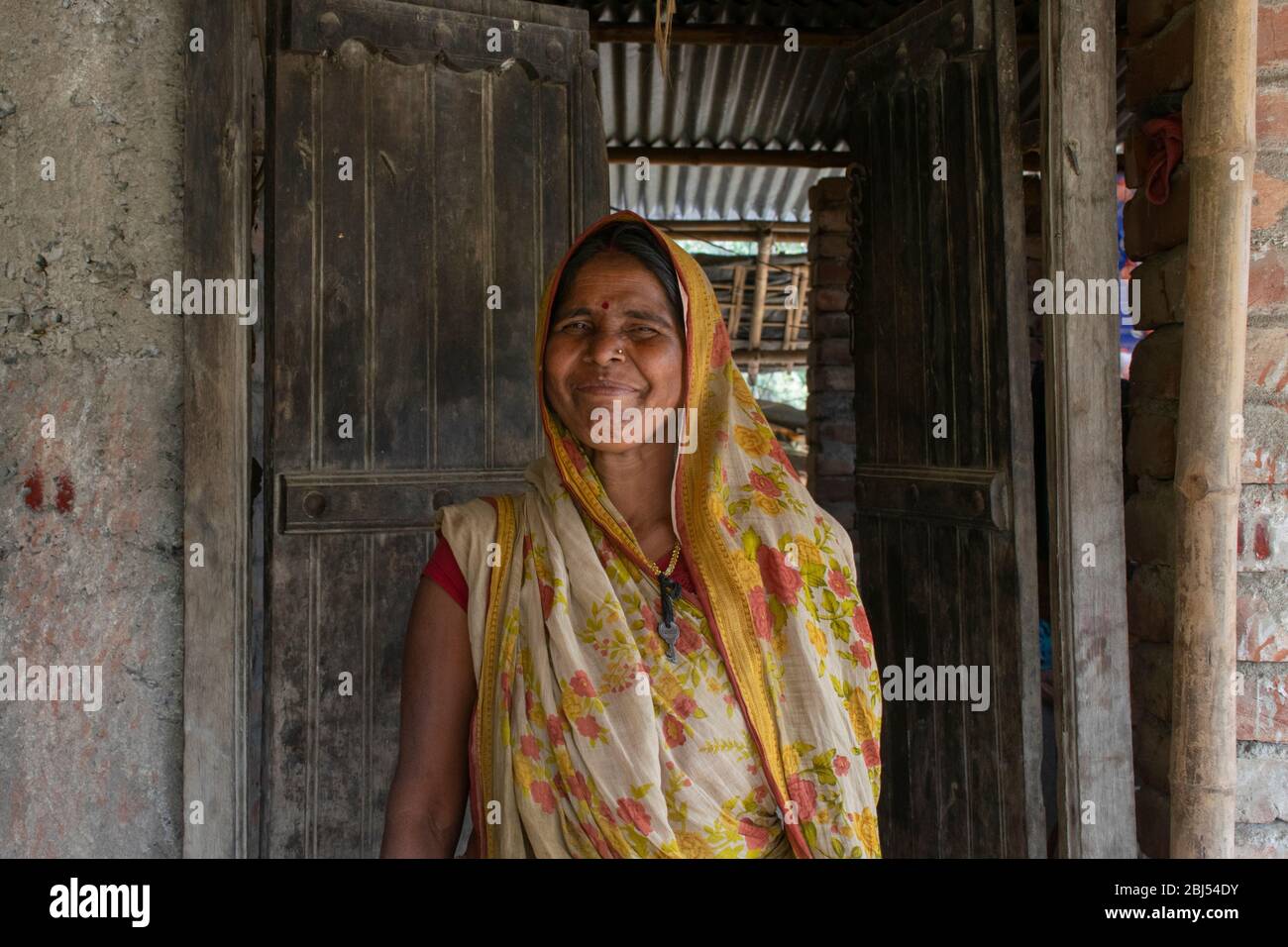 heureuse femme rurale debout à la porte Banque D'Images