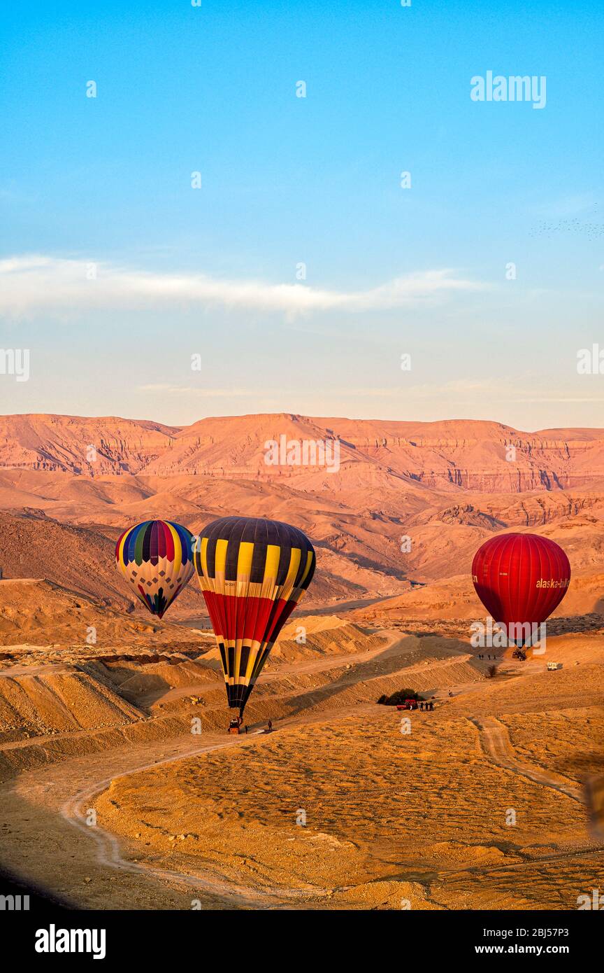 Des ballons d'air chaud atterrissent dans le désert autour de la vallée des rois après un vol matinal Banque D'Images