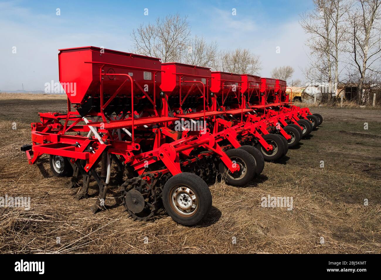 Moissonneuse-batteuse et charrue rouges, pulvérisateur traîné avec réservoir et liquide. Machines pour l'agriculture et l'agriculture. Dispositifs d'élevage de charrue Banque D'Images