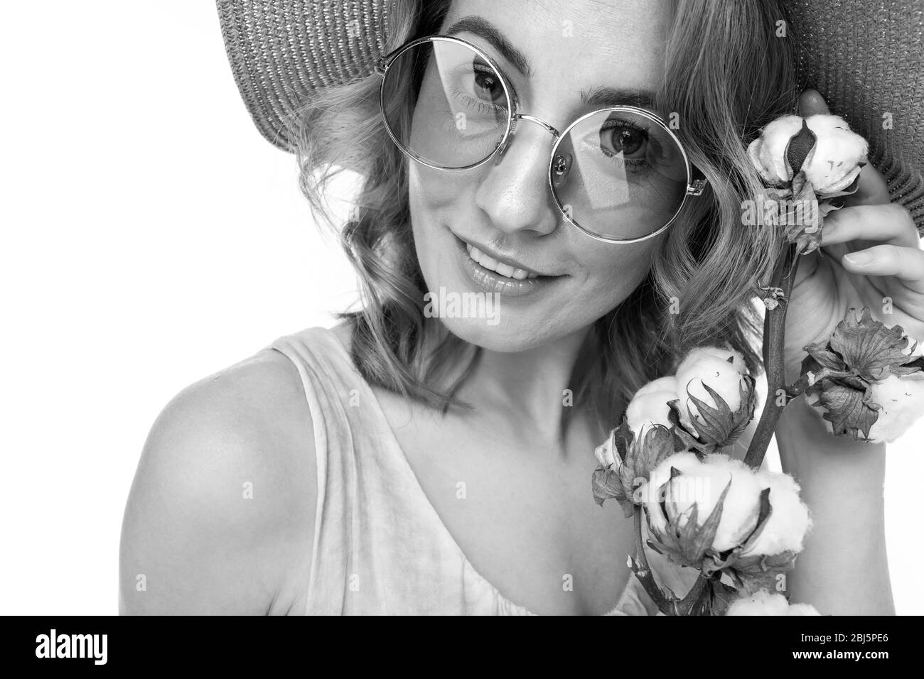 Portrait d'une femme caucasienne avec des cheveux rouges, joli visage dans une belle robe légère et un grand chapeau posant avec la fleur Banque D'Images