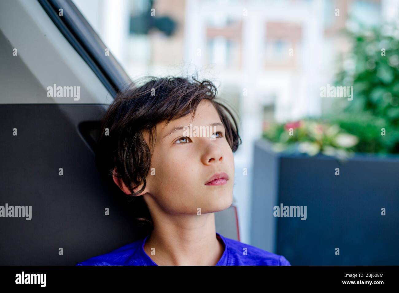 Un jeune garçon se penche dans le tronc d'un minibus regardant le ciel Banque D'Images