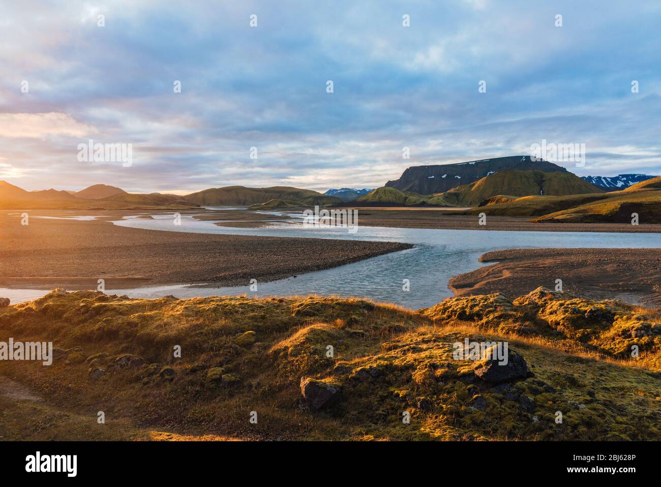 Le lever du soleil se fait jour au-dessus du paysage de rivière et de montagne en Islande Banque D'Images