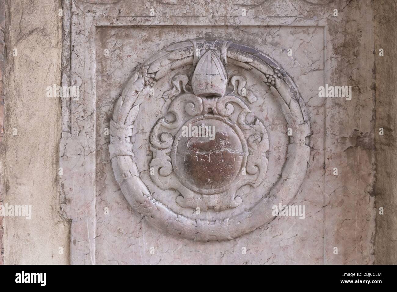 Bas-relief sur l'un des murs de Cracovie. Vieux manteau d'armes avec un lion et un tiara papale. Banque D'Images