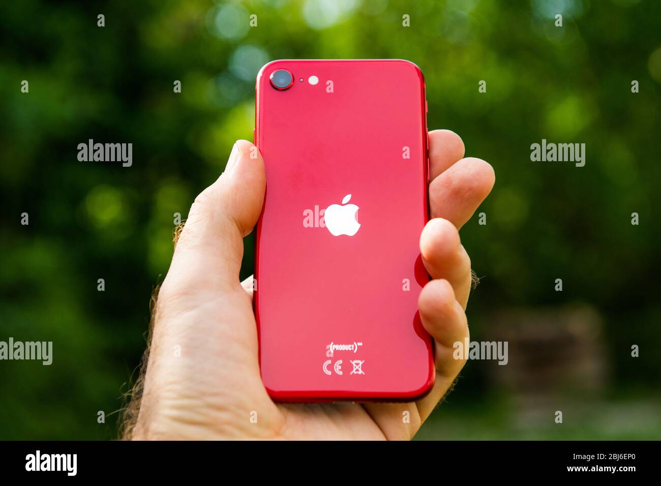 Paris, France - 24 avril 2020: Main d'homme montrant le logotype arrière sur le nouveau budget iPhone se par Apple Computers touch ID, caméra arrière à objectif unique et iPhone 8 design avec des éléments internes à partir de la version 11 Pro Banque D'Images