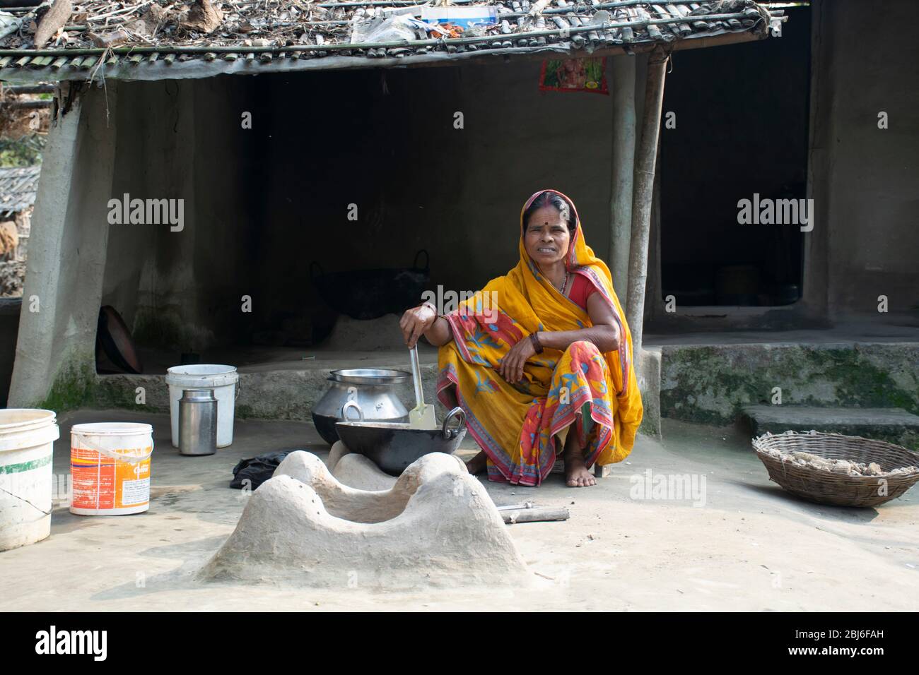 Rural Indian Woman cuisine de nourriture dans la cuisine à l'aide de poêle à bois Banque D'Images