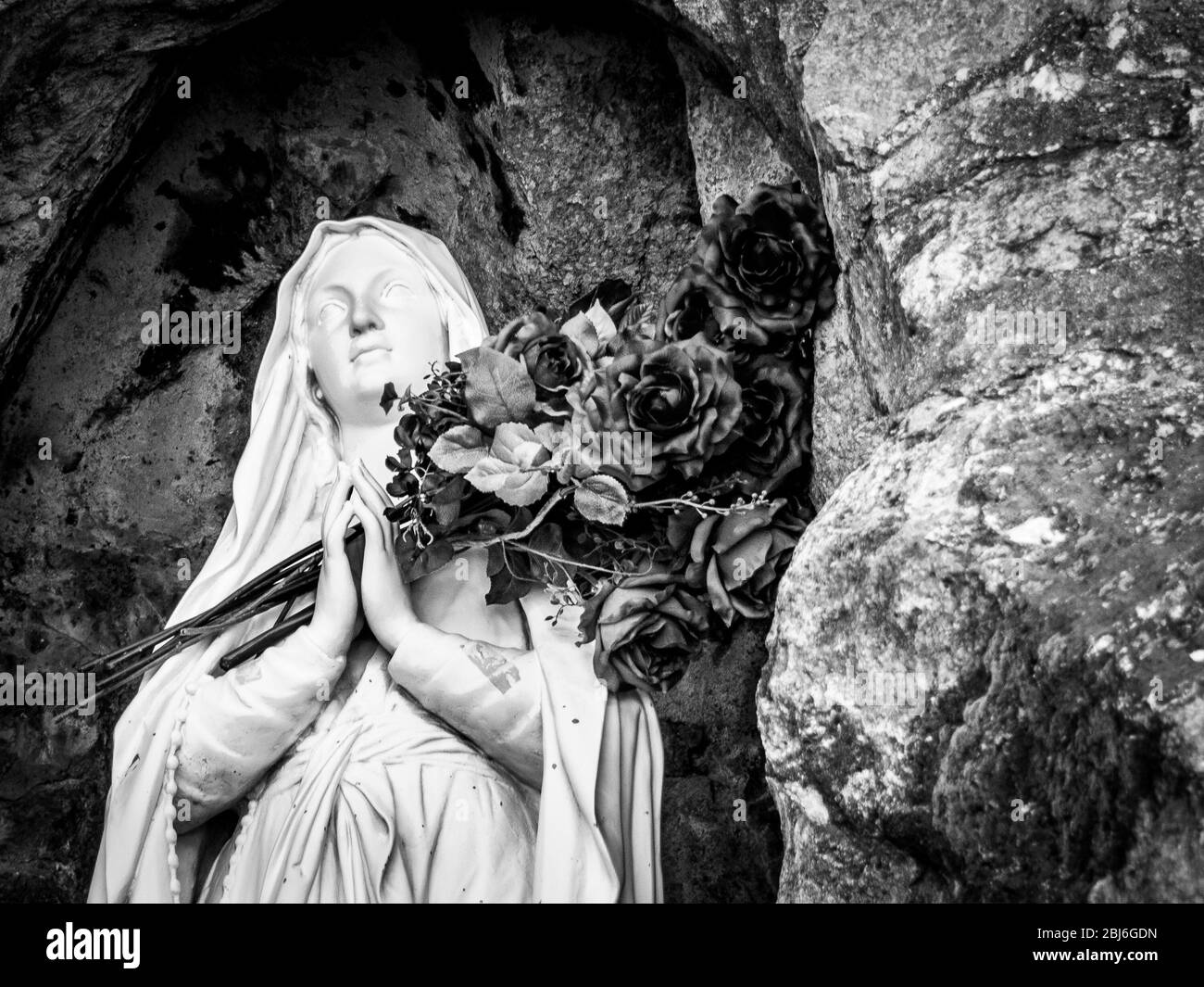 La statue de la Vierge Marie possède un bouquet de fleurs séchées près de Mission San Xavier del bac, au sud de Tucson, en Arizona. Banque D'Images