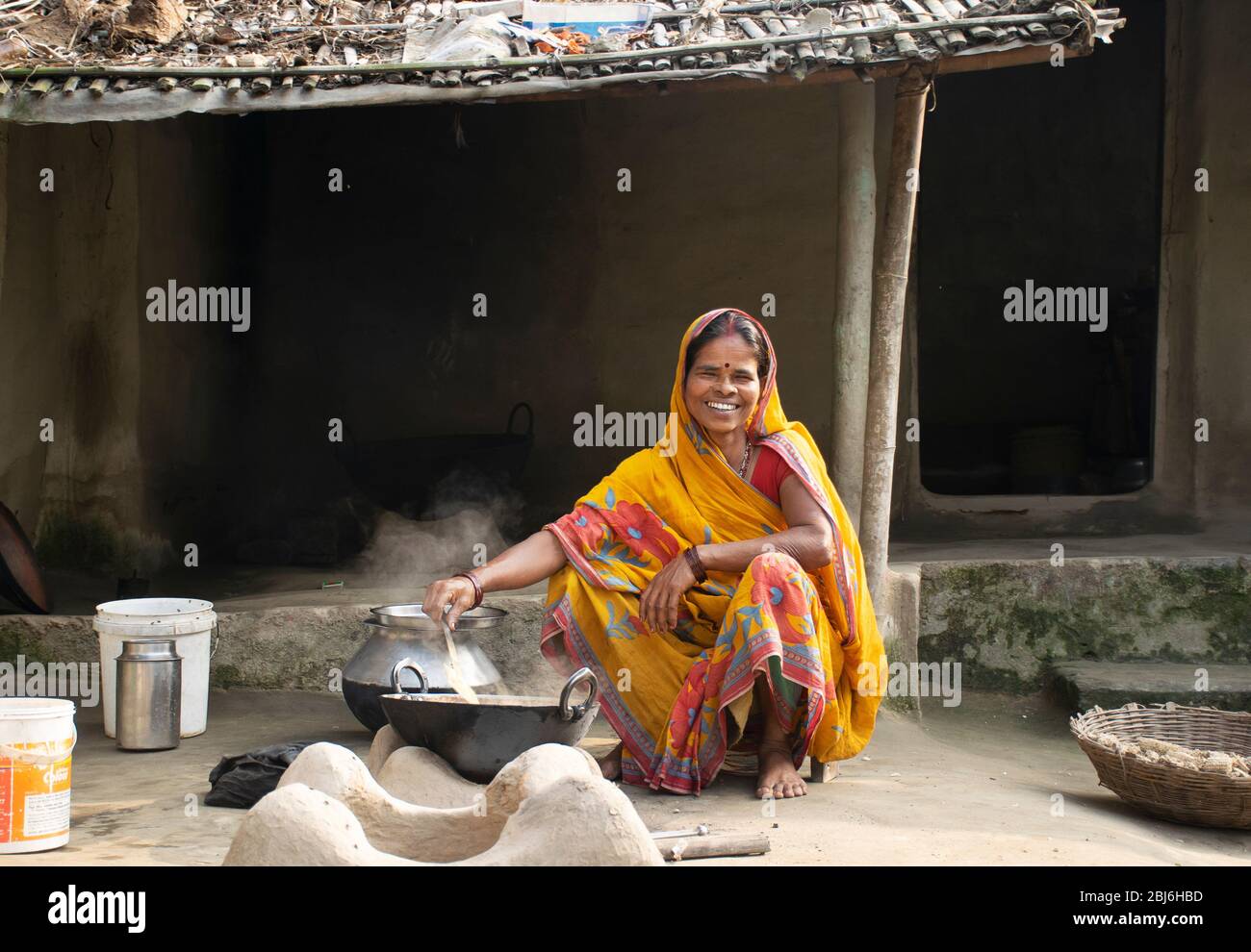 Rural Indian Woman cuisine de nourriture dans la cuisine à l'aide de poêle à bois Banque D'Images