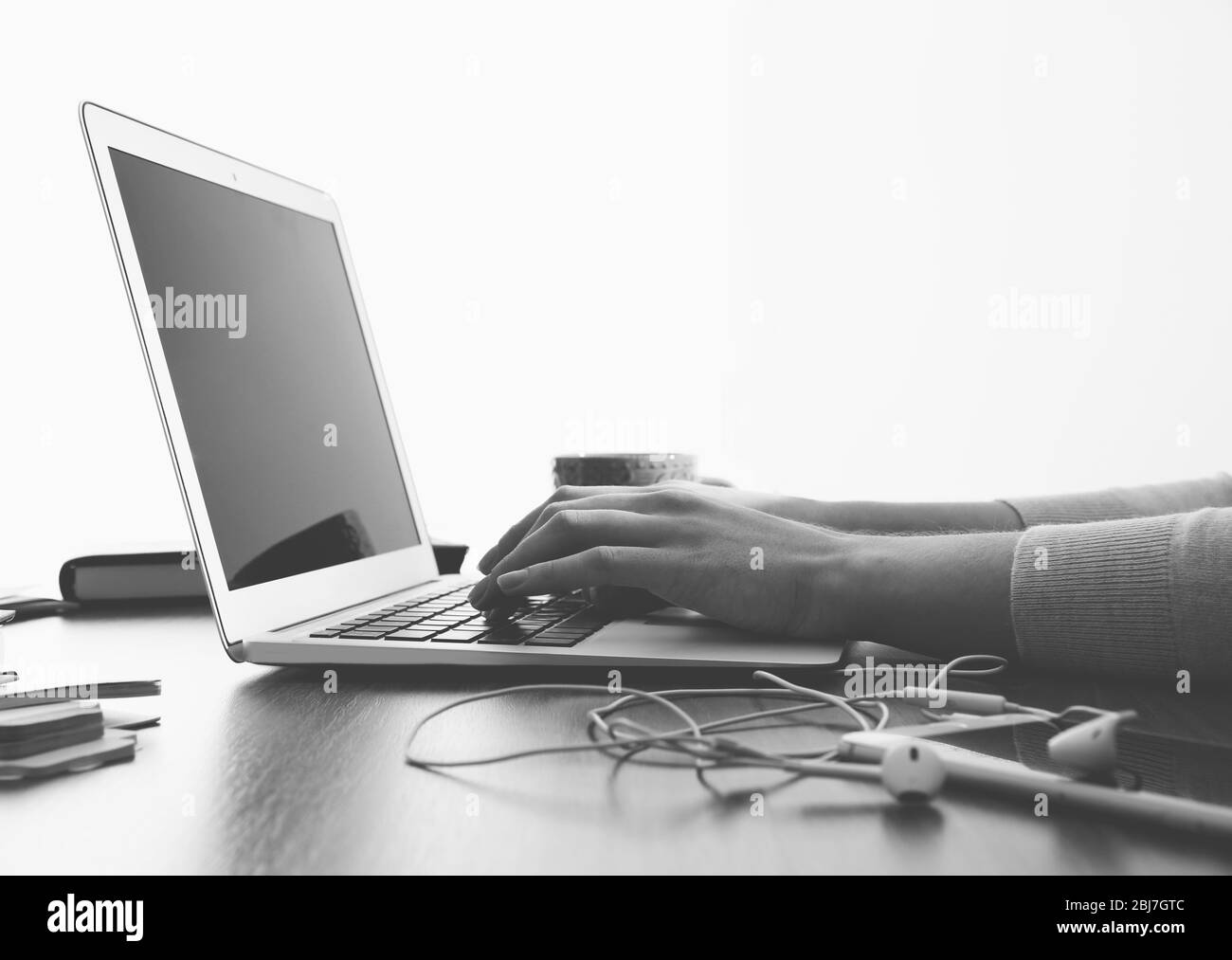 Les mains des femmes travaillant avec un ordinateur portable au bureau sur fond de fenêtre Banque D'Images