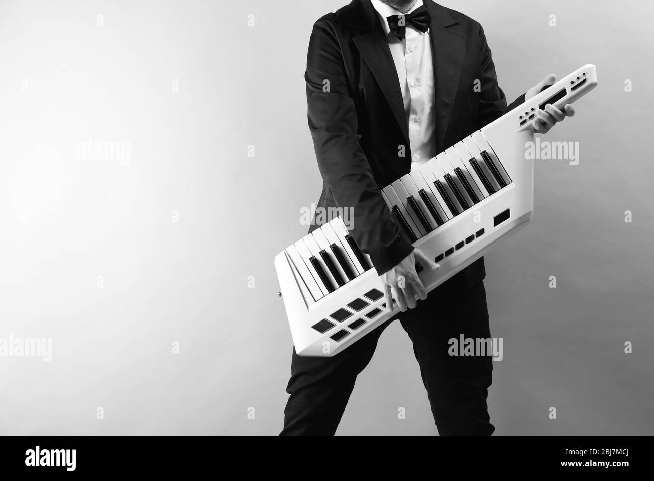 Mains mâles avec synthétiseur sur fond de paroi légère Banque D'Images