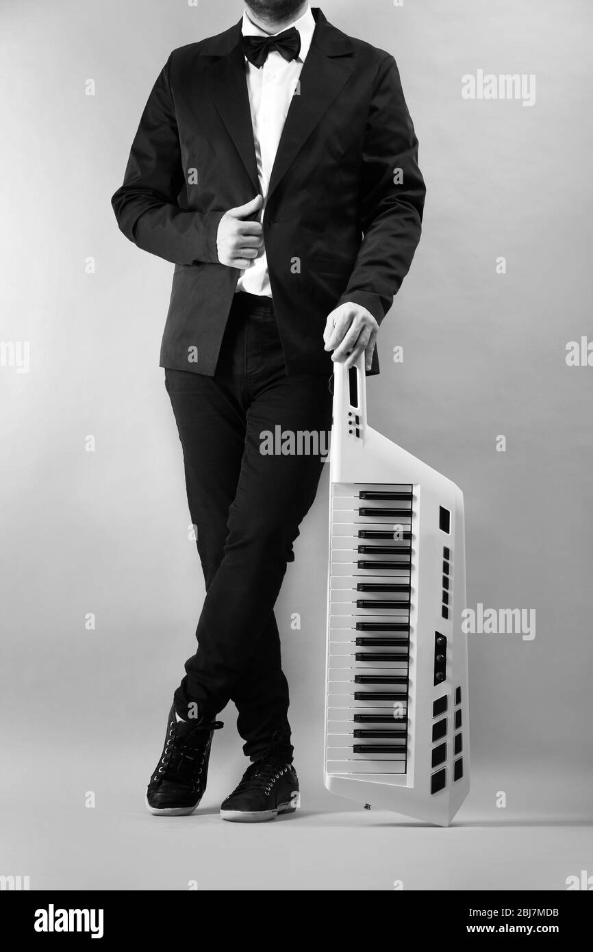 Mains mâles avec synthétiseur sur fond de paroi légère Banque D'Images