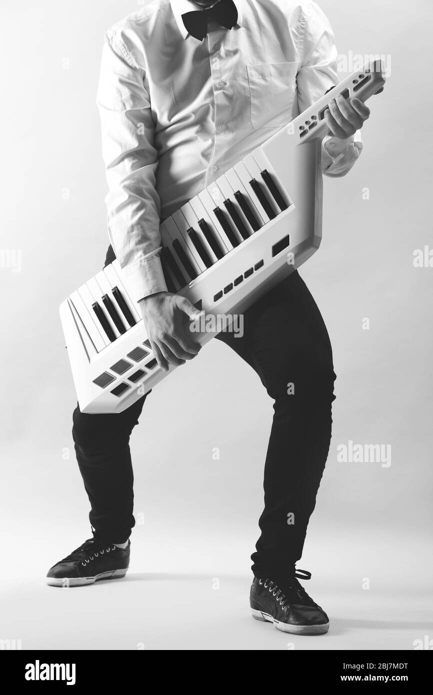 Mains mâles avec synthétiseur sur fond de paroi légère Banque D'Images