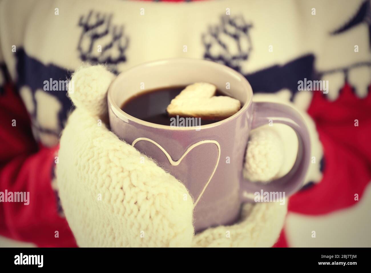 Mains féminines dans des moufles chaudes tenant une tasse de café chaud  avec guimauve de coeur, gros plan Photo Stock - Alamy