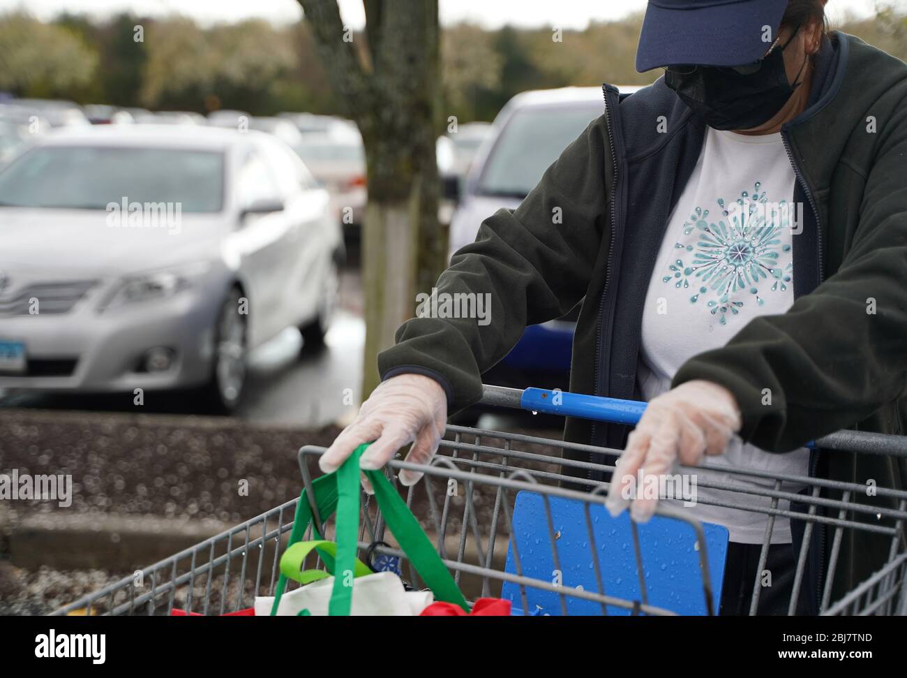 Cromwell, CT / USA - 20 avril 2020: Femme en masque et gants se prépare pour le voyage à l'épicerie (se concentrer sur le masque/visage) Banque D'Images