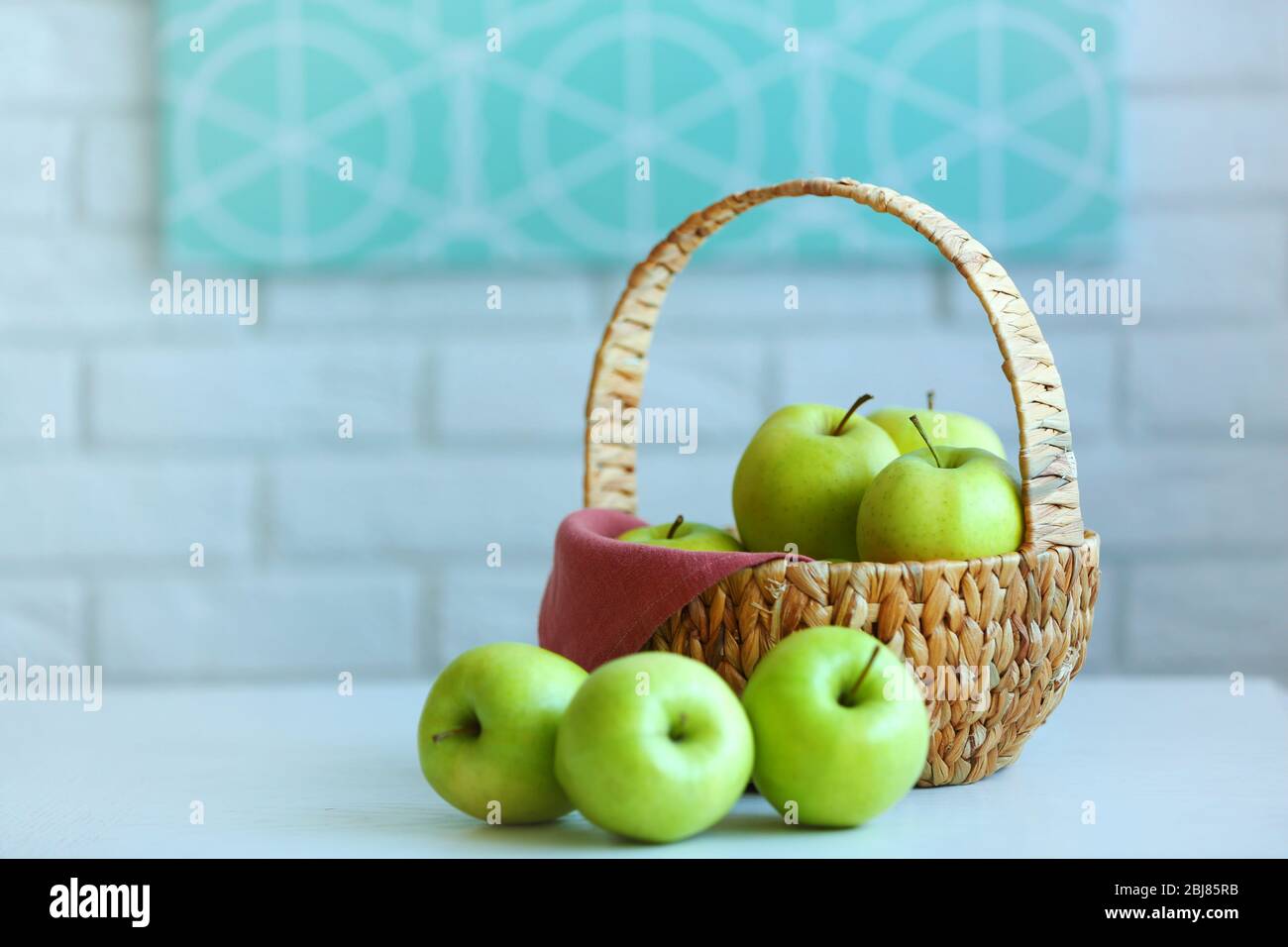 Pommes vertes mûres dans le panier sur une table de cuisine Banque D'Images