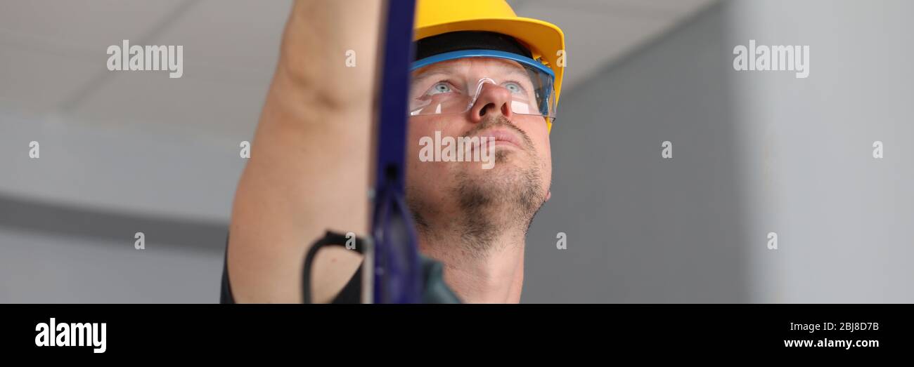 Workman sur l'échelle au travail Banque D'Images