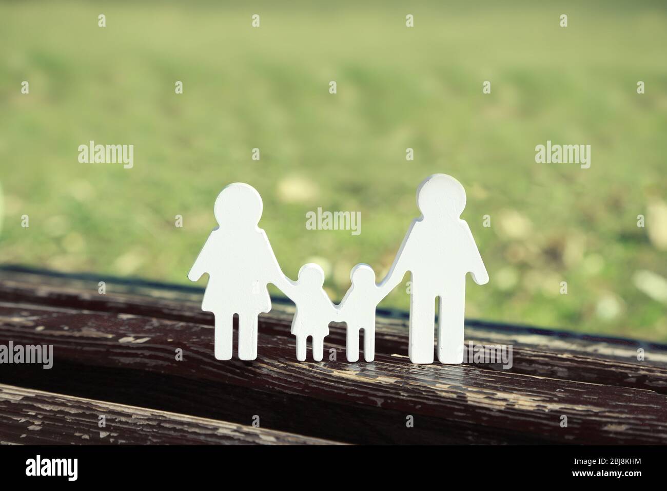 Des personnages familiaux sur un banc dans le parc Banque D'Images