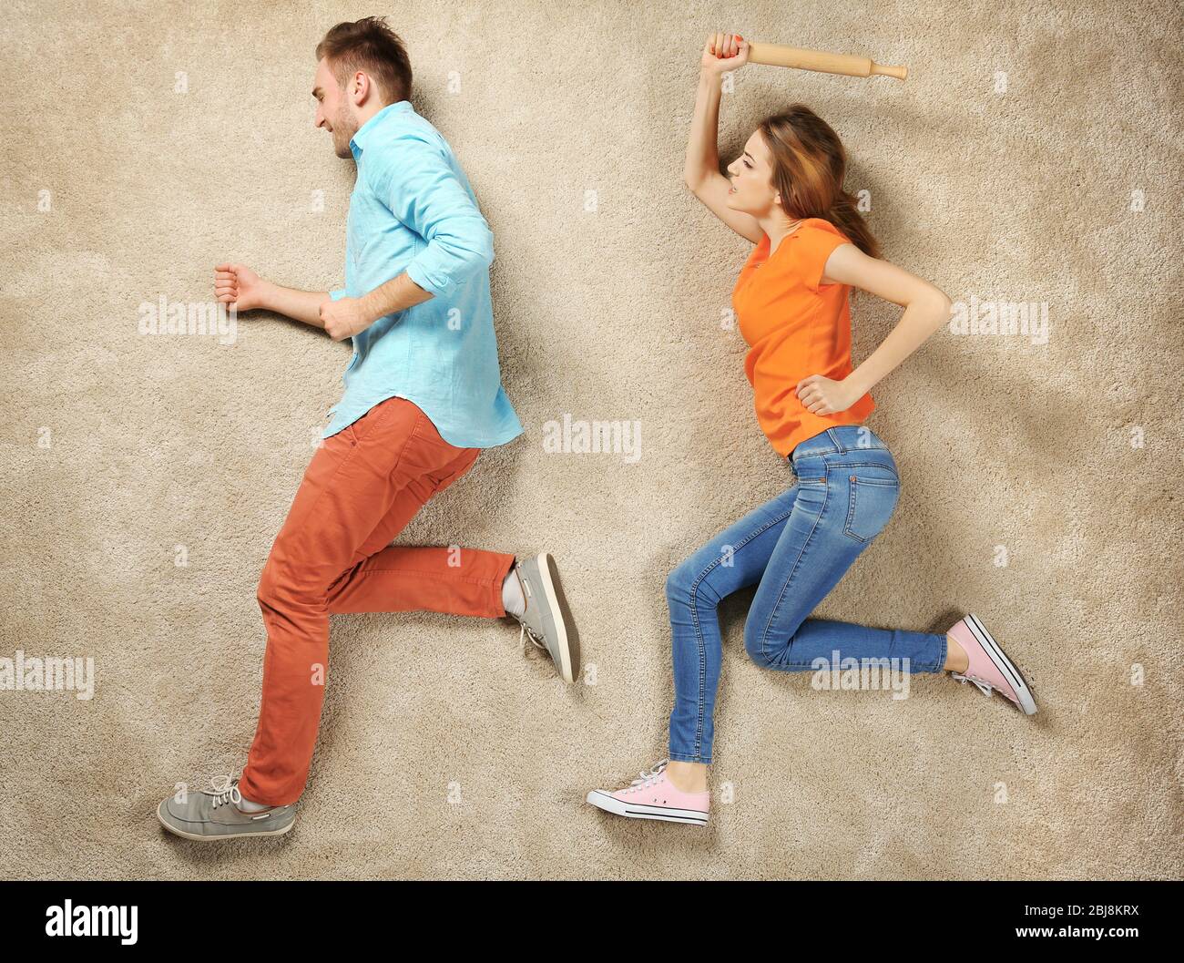 Simulation de scène, femme rattrapant avec l'homme et essayant de le battre  avec un roulement Photo Stock - Alamy