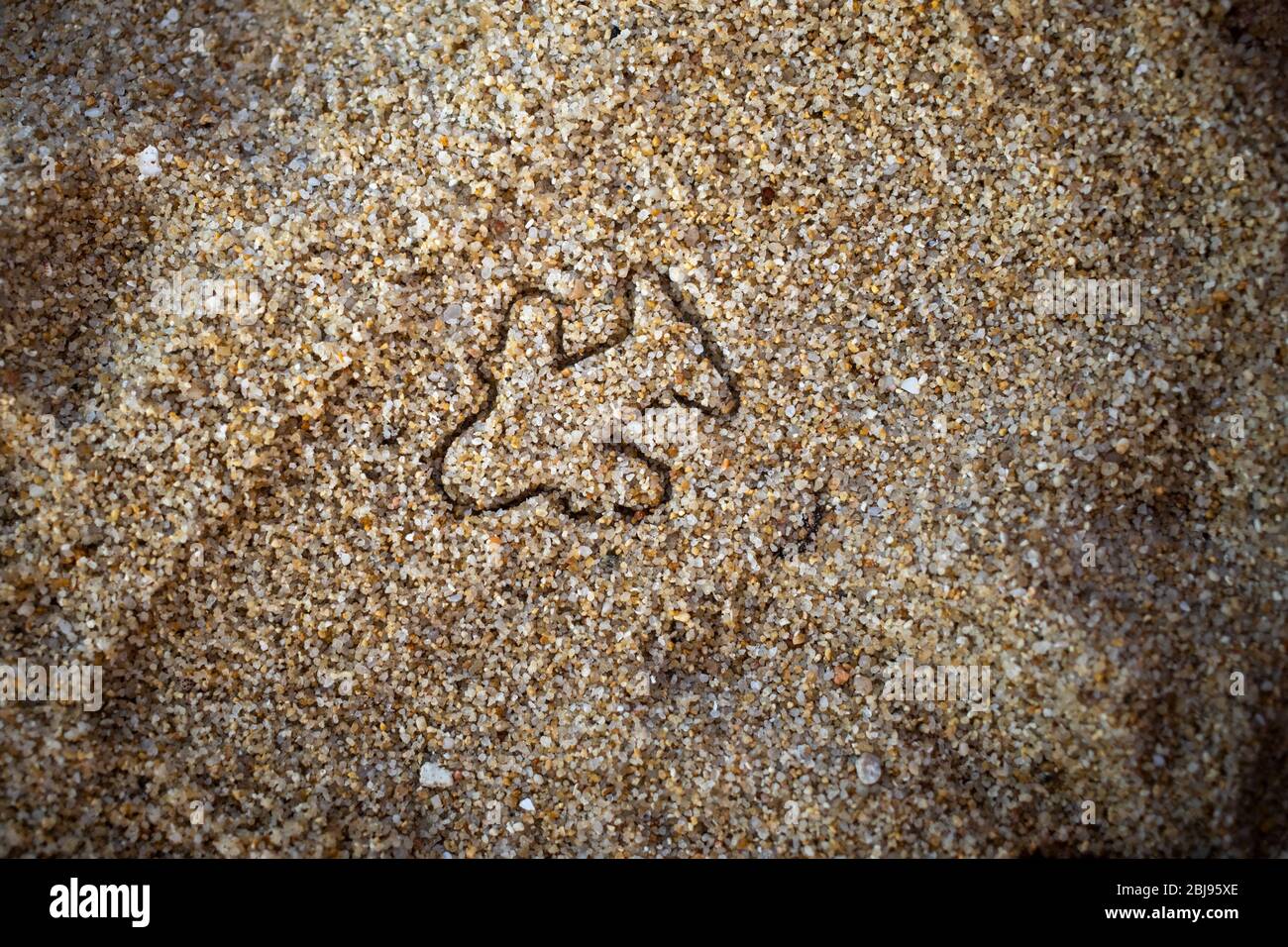 concept d'ouverture de vols entre pays, fin de la quarantaine de la planète pandémique. figurine d'un avion sur le sable d'une plage. vue de dessus. Banque D'Images