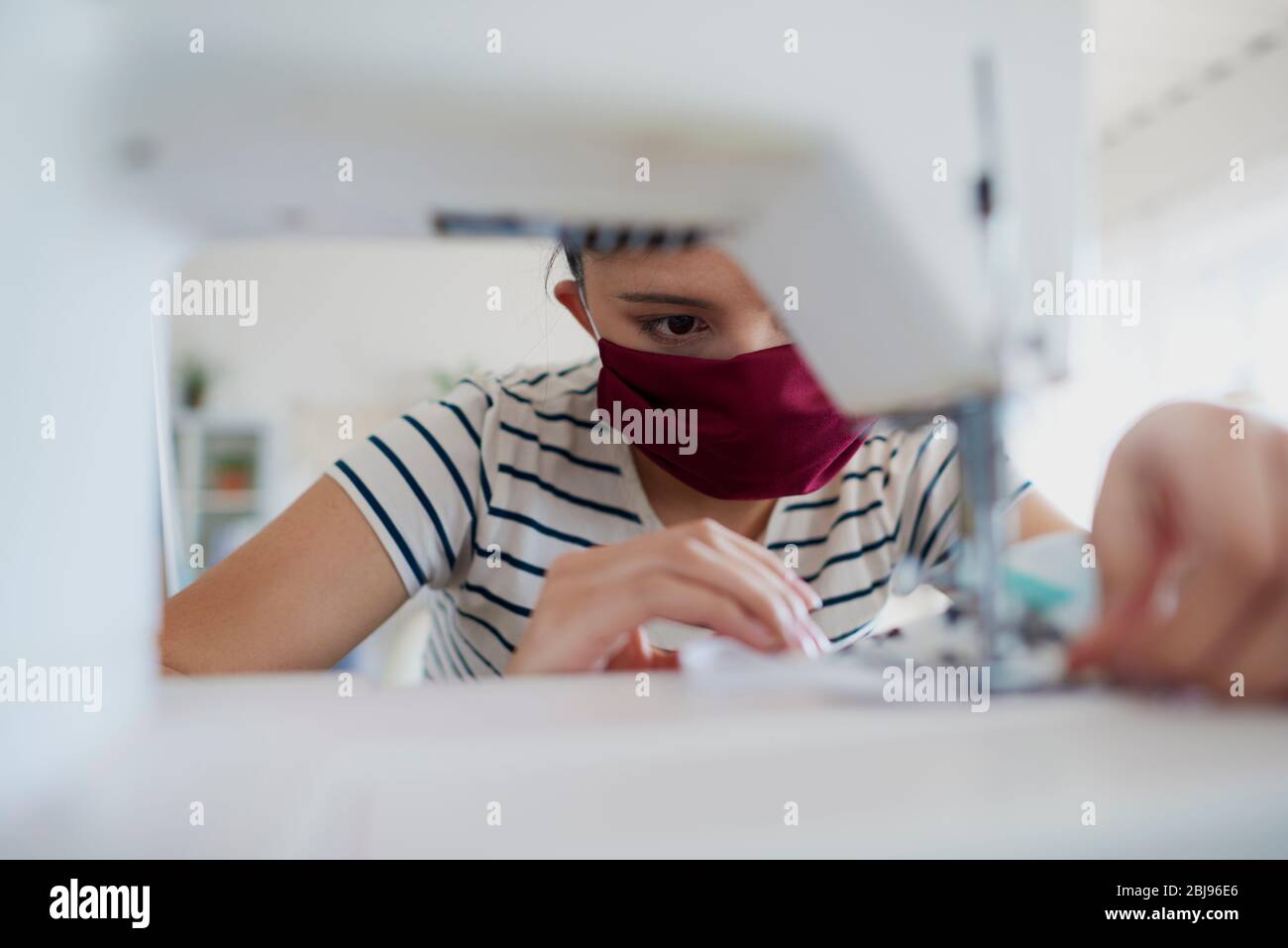 Gros plan sur la femme asiatique qui couture un masque de pollution Banque D'Images
