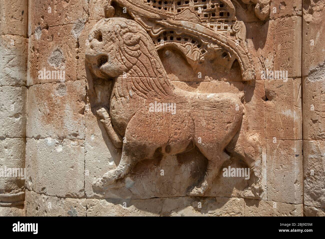Une figure de lion en pierre sculptée adjacente à une porte dans la première cour du palais Ishak Pasa à Dogubayazit en Turquie. Banque D'Images