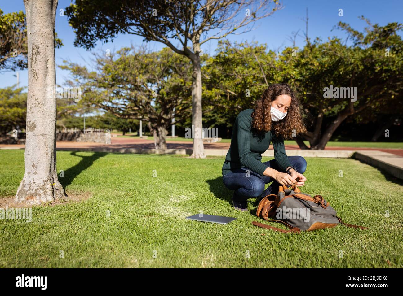 Femme caucasienne portant un masque de protection dans un jardin Banque D'Images