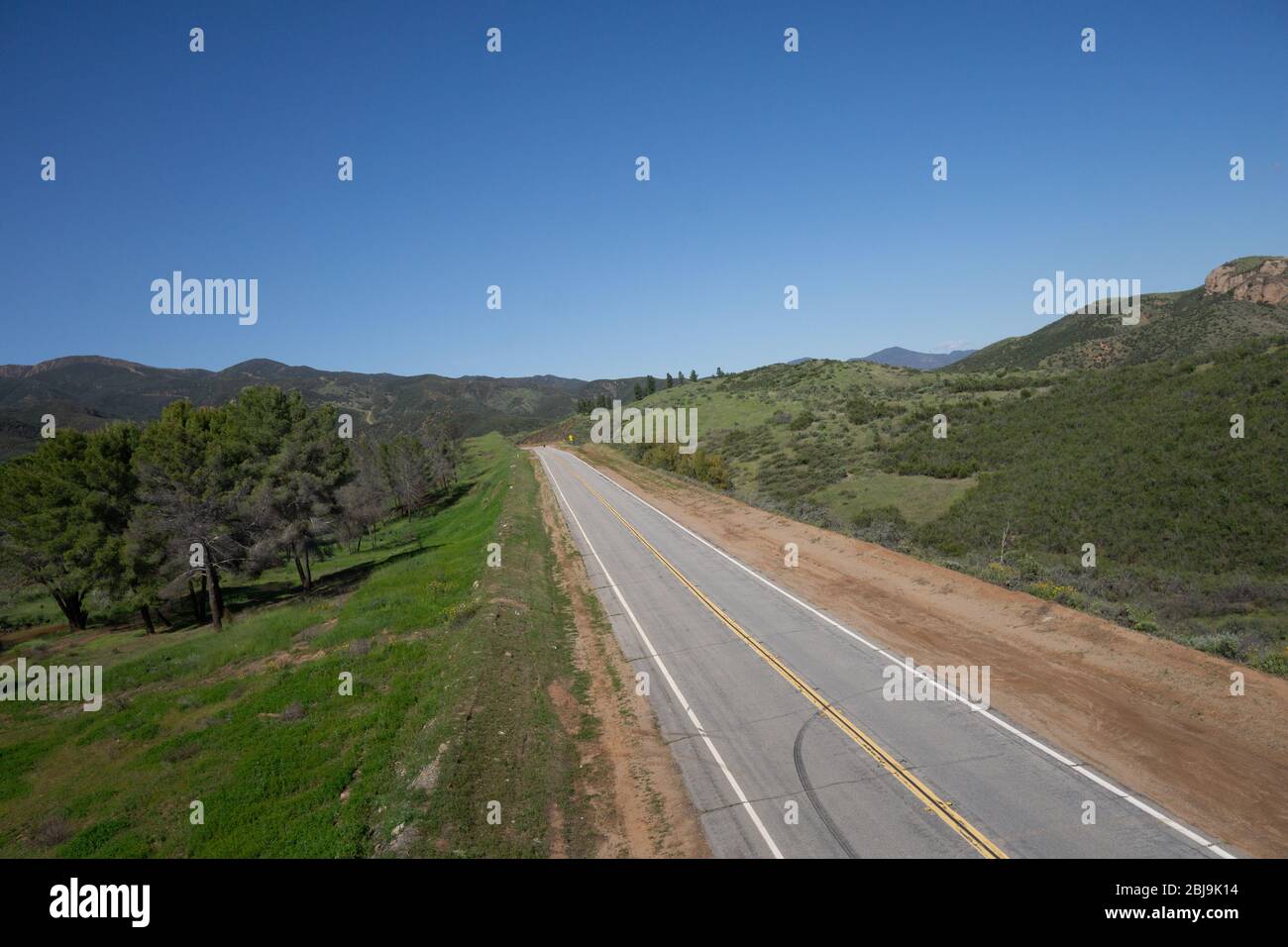Deux voies de circulation tout droit dans le vaste désert vert des collines du sud de la Californie. Banque D'Images