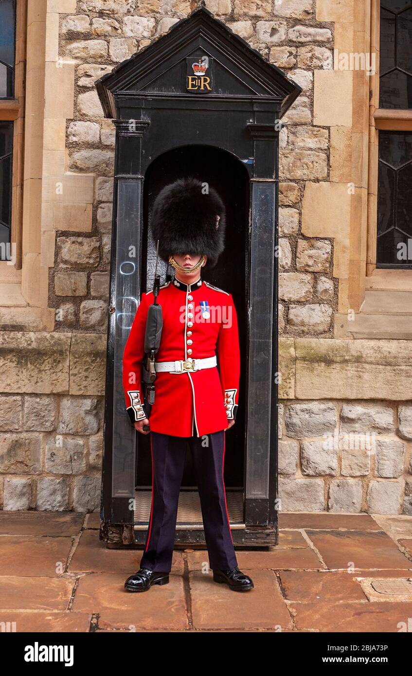 Garde-corps en barbu debout en service en dehors de sa boîte de sénion en service à la Tour de Londres (UNESCO) un Palais Royal historique, Londres, Angleterre, Royaume-Uni Banque D'Images