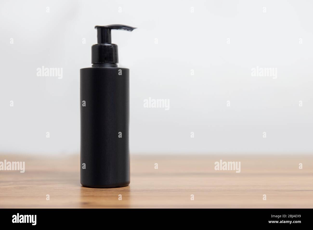 Maquette de bouteille noire pour shampooing cosmétique sur fond blanc simple Banque D'Images