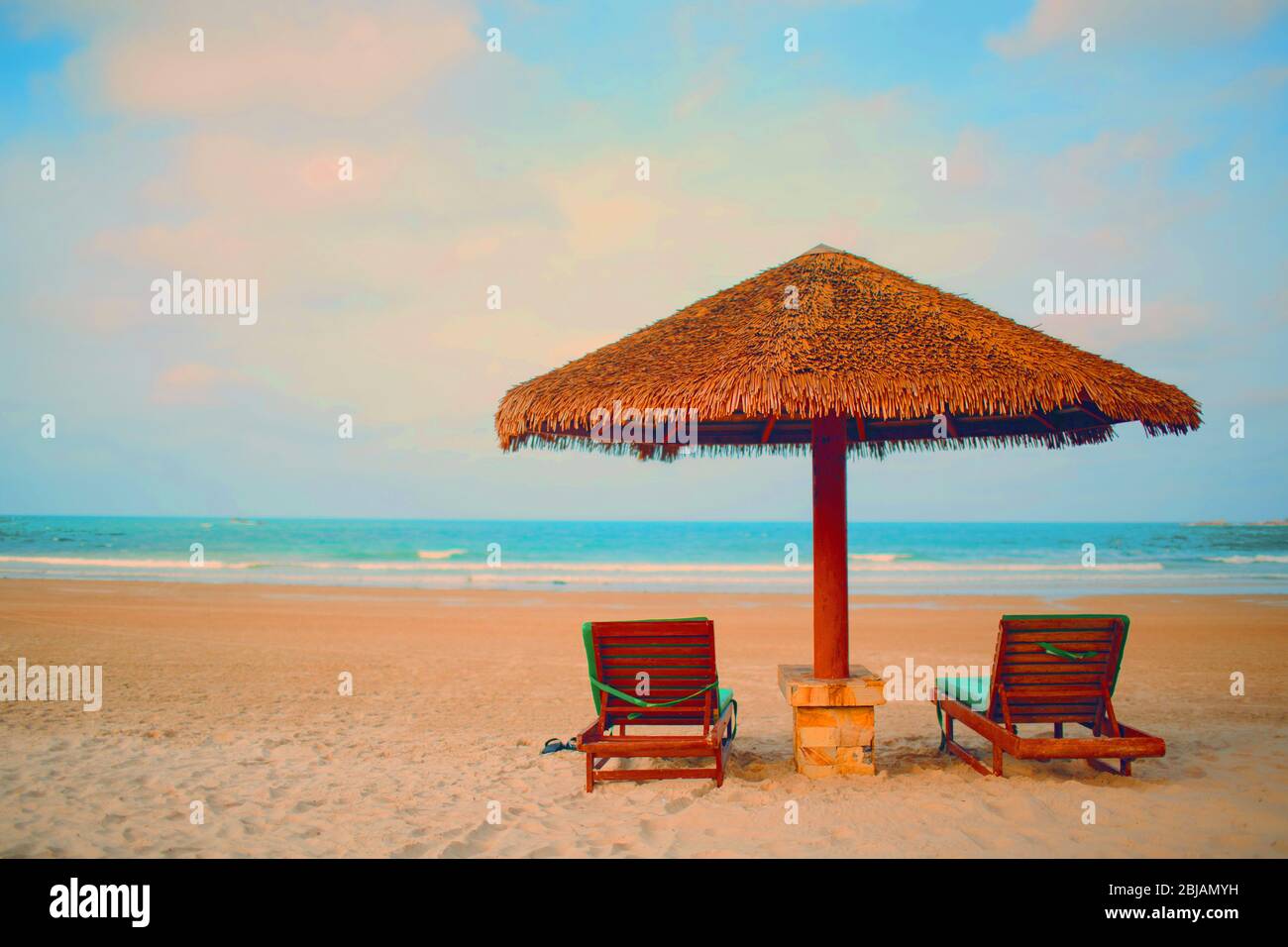 Deux chaises longues et un parasol sur la plage et le soir Banque D'Images