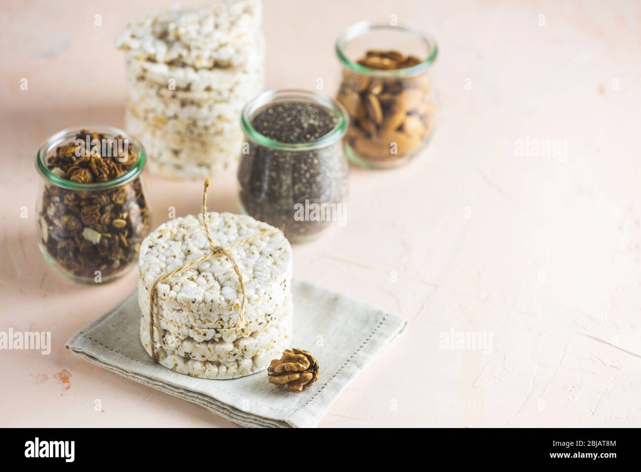 Gateaux De Riz Americains A La Farine En Cas Sains Avec Amandes Raisins Secs Arachides Pistaches Dans Des Bocaux En Verre Sur Une Surface En Beton Rose Clair Espace De Copie Pour Vous Gateaux De Riz Americains A La Farine En Cas Sains Avec Amandes Raisins Secs Arachides Pistaches Dans Des Bocaux En Verre Sur Une Surface En Beton Rose Clair Espace De Copie Pour Vous