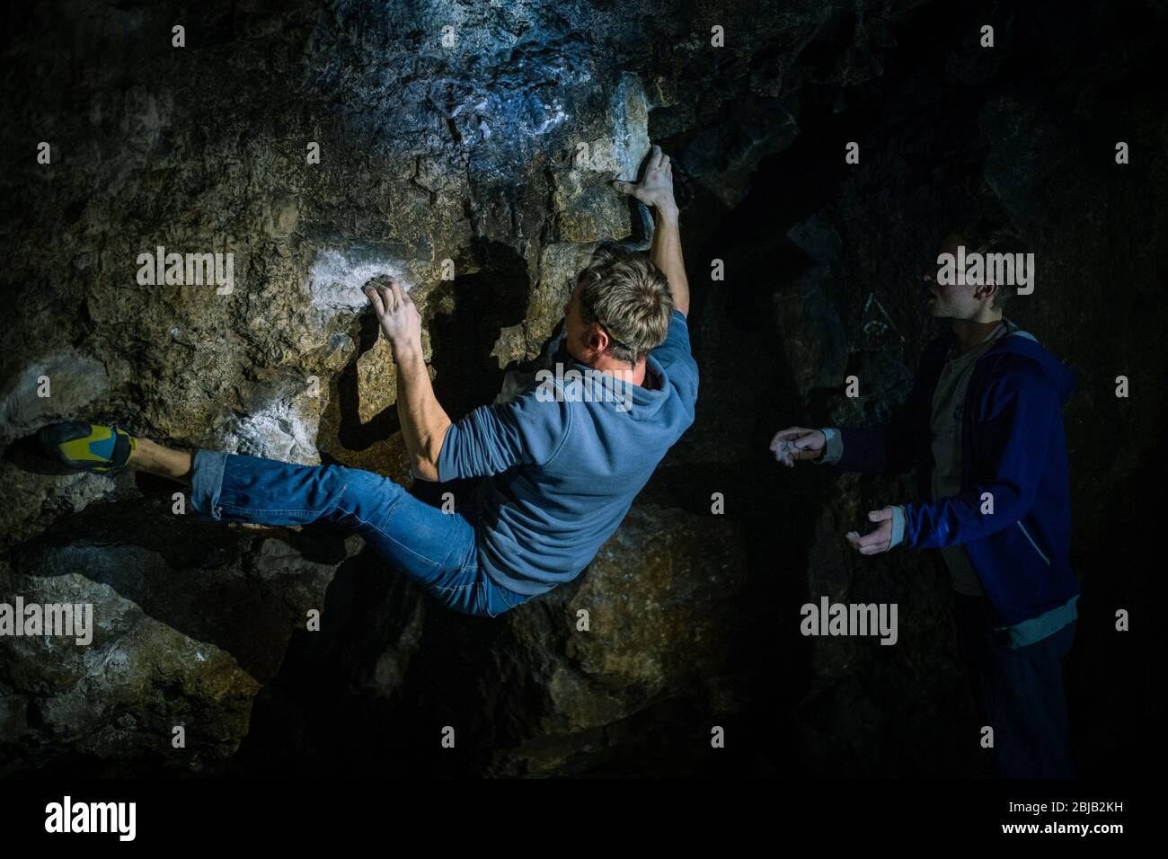 L'homme fait un bloc dans la grotte de Twardowski. Bourage dans le rock. Grotte de Twardowski Banque D'Images