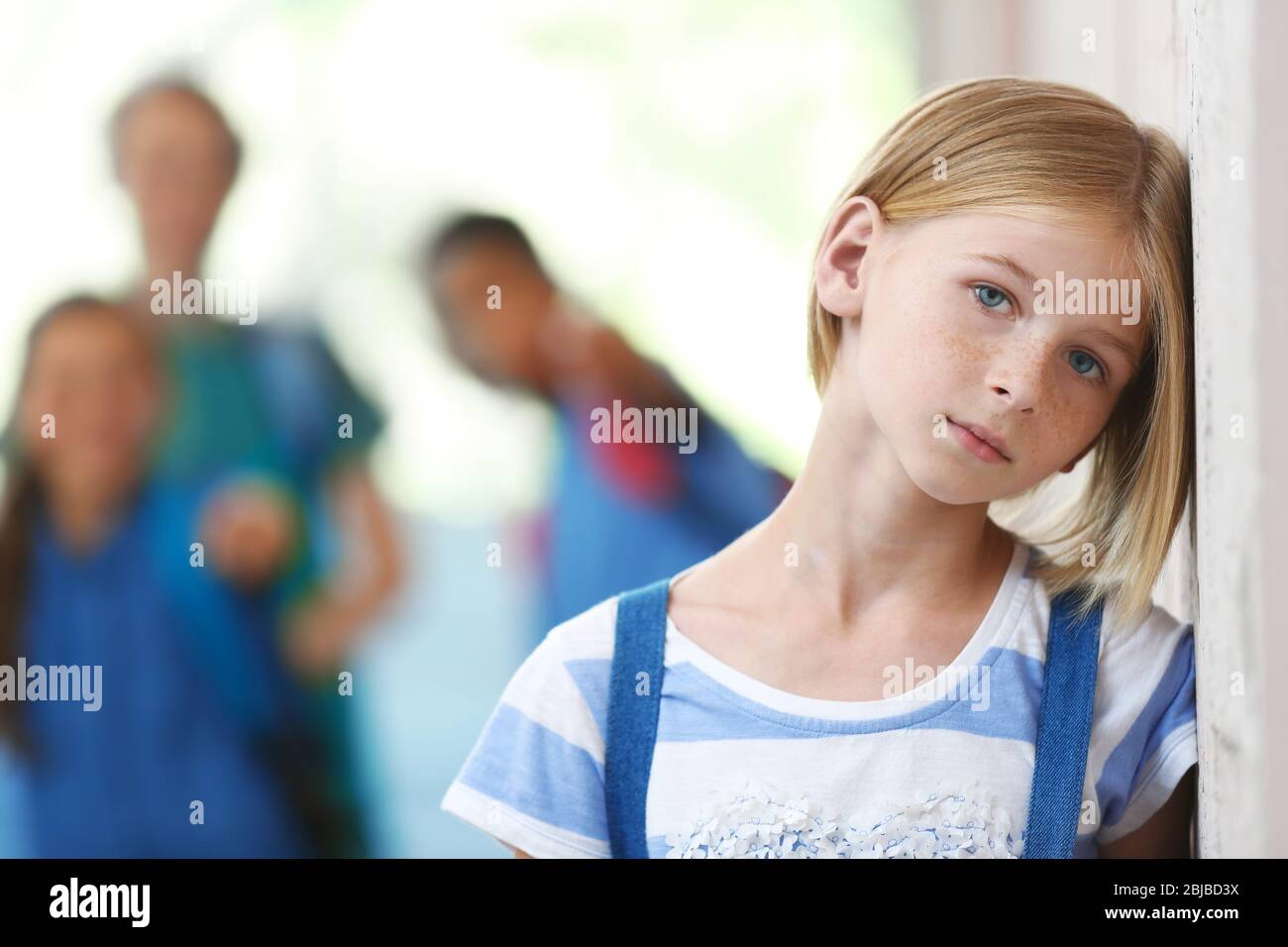 Une fille triste dans le couloir de l'école Banque D'Images