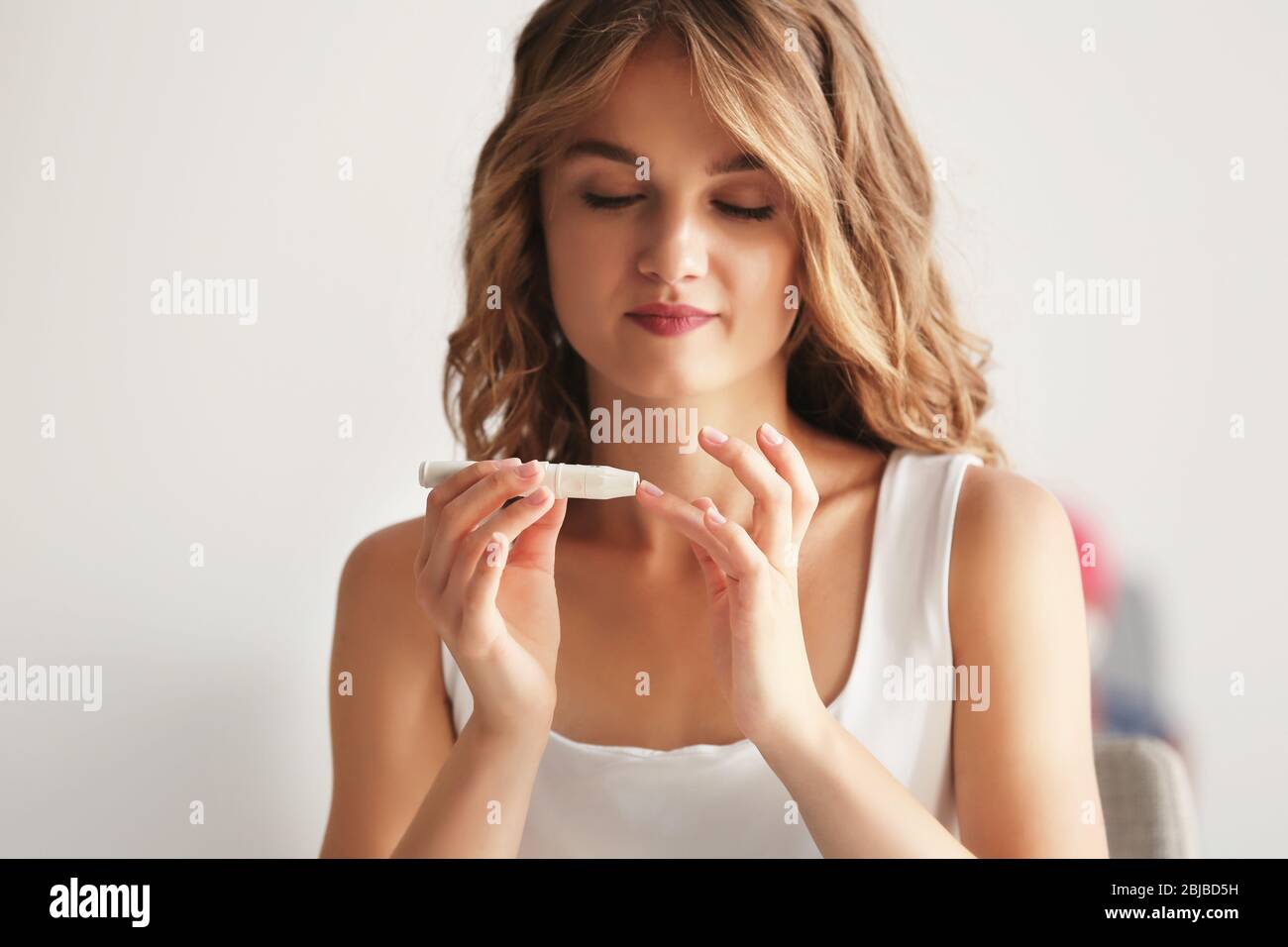 Femme utilisant une lancelle sur le doigt Banque D'Images