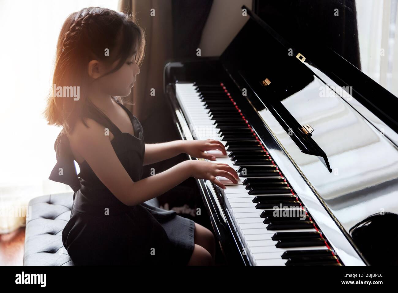 les enfants de fille asiatique pratiquent le piano pour l'habileté de la musique pour l'occupation future. Banque D'Images