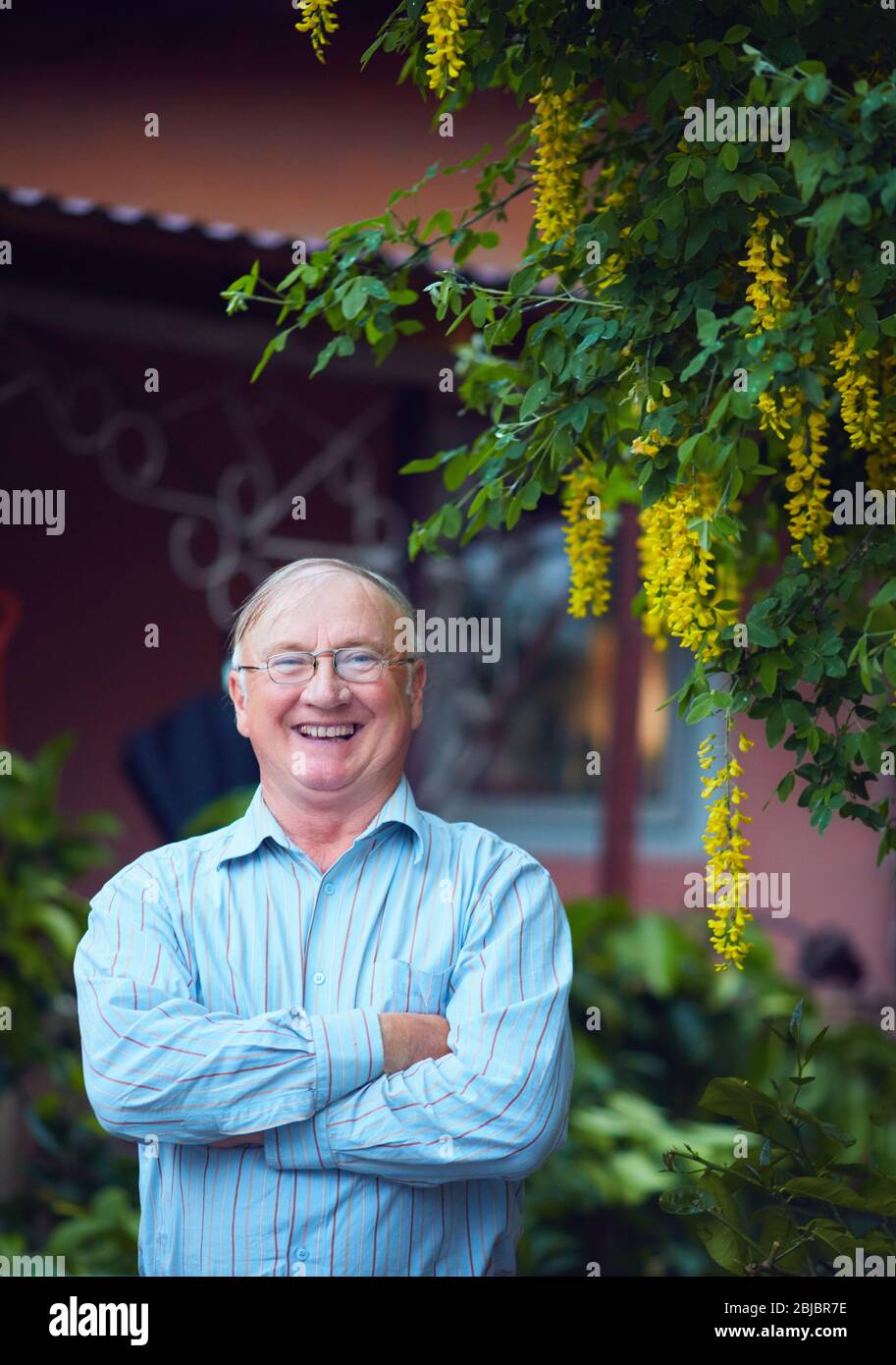 portrait d'un homme mûr heureux et confiant sur sa propre cour Banque D'Images