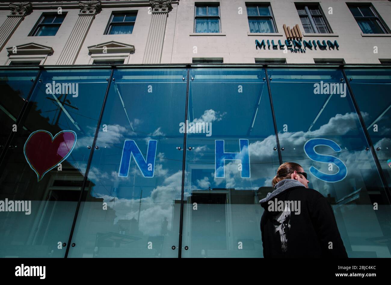 Un homme passe devant l'hôtel Millenium, Glasgow, avec les mots « Love NHS » sur les fenêtres. Banque D'Images