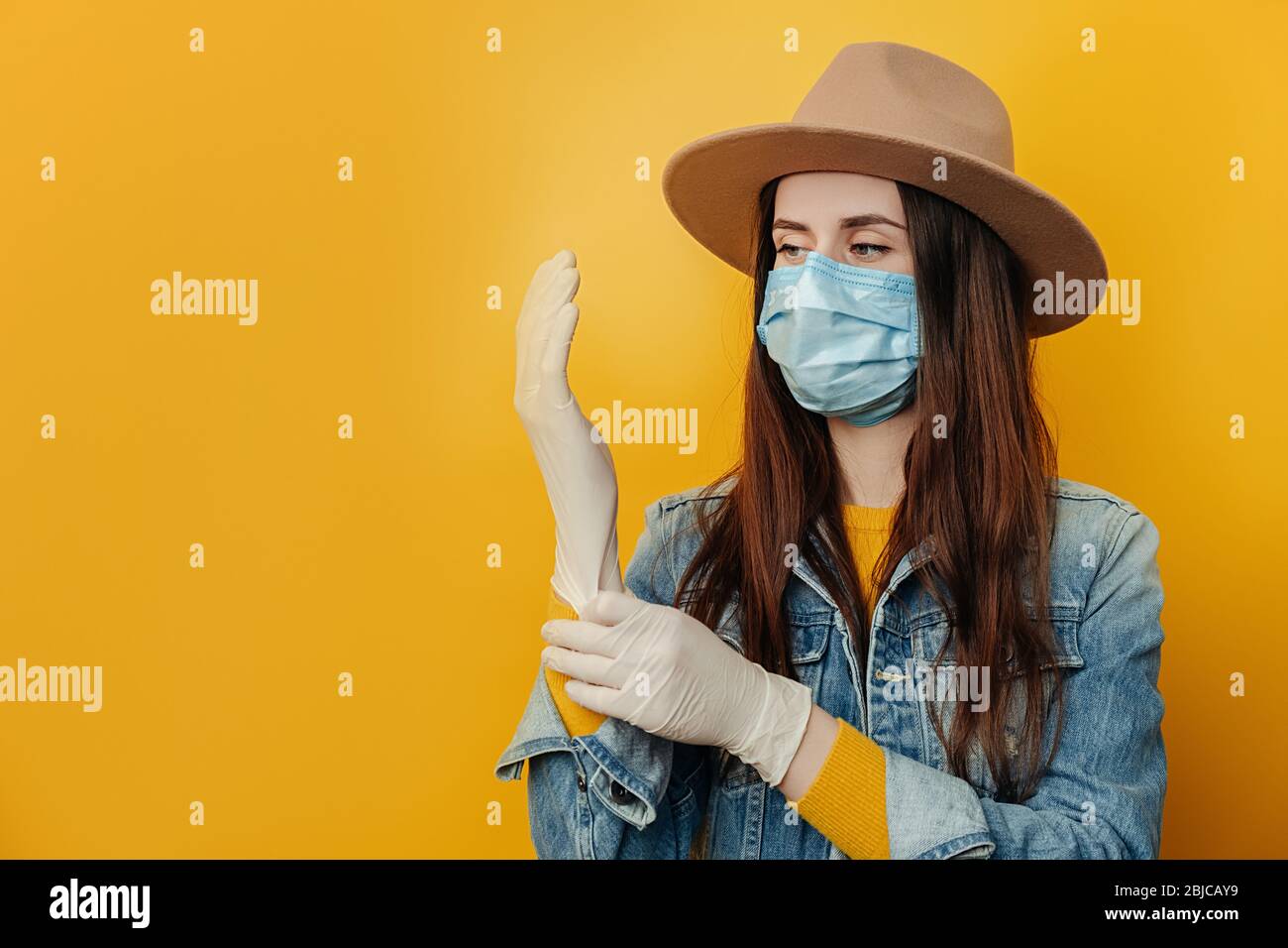 Les jeunes femmes portent un masque médical de protection pour ne pas infecter d'autres personnes, mettent des gants médicaux, se préparant à un voyage dangereux pendant l'éclosion d'un cor Banque D'Images