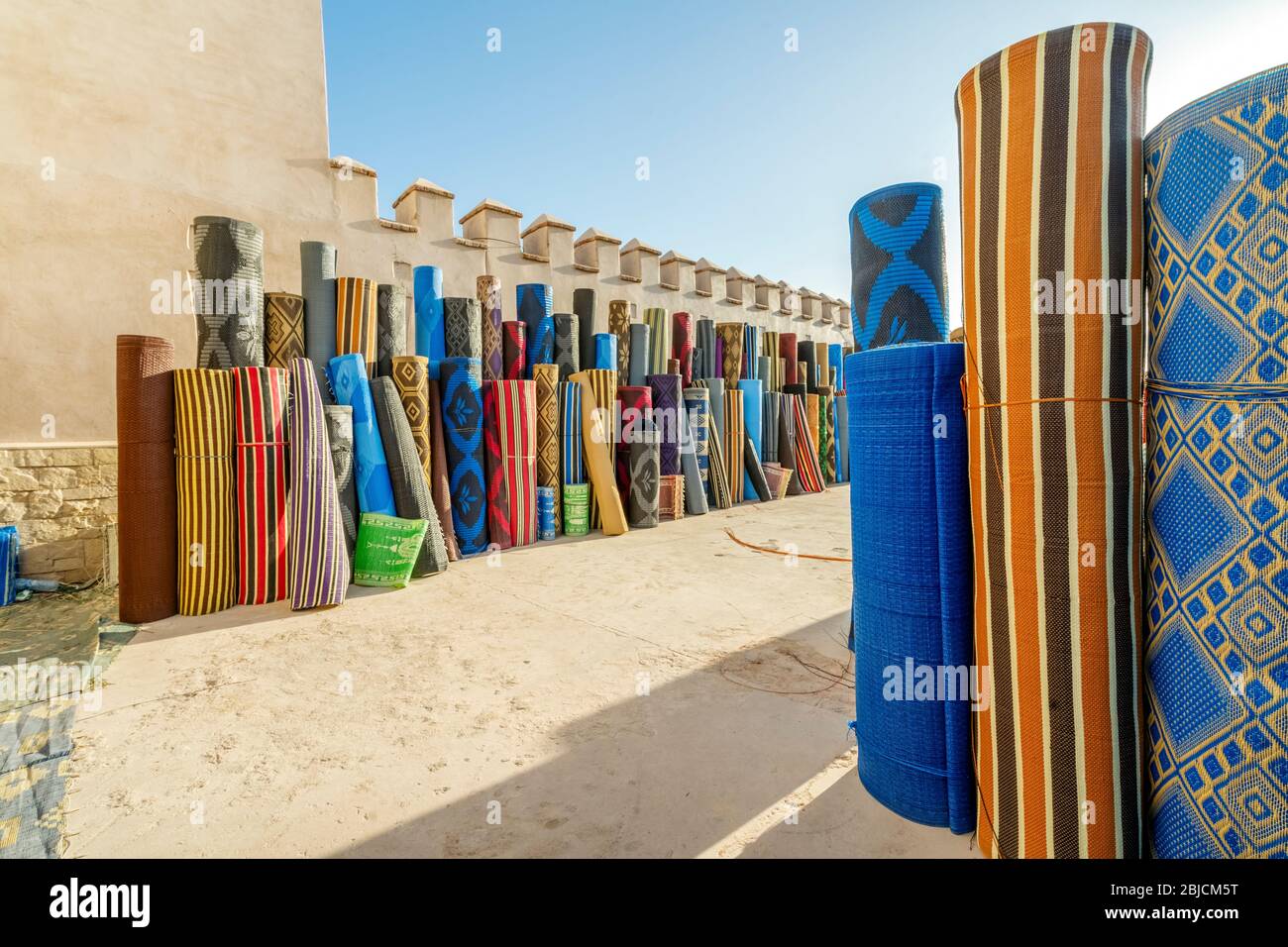 De nombreux rouleaux de tapis en plastique vendus sur le marché en plein air du Northafrican à Agadir, au Maroc Banque D'Images