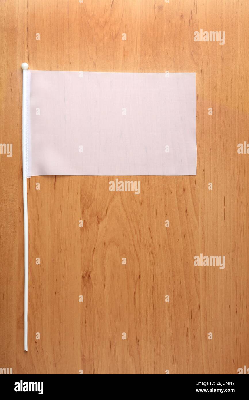 Drapeau blanc pour la marque sur table en bois Banque D'Images
